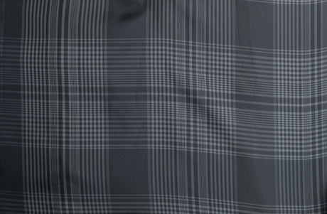Graues Karomuster mit vertikalen und horizontalen Linien in verschiedenen Schattierungen auf Stoff.