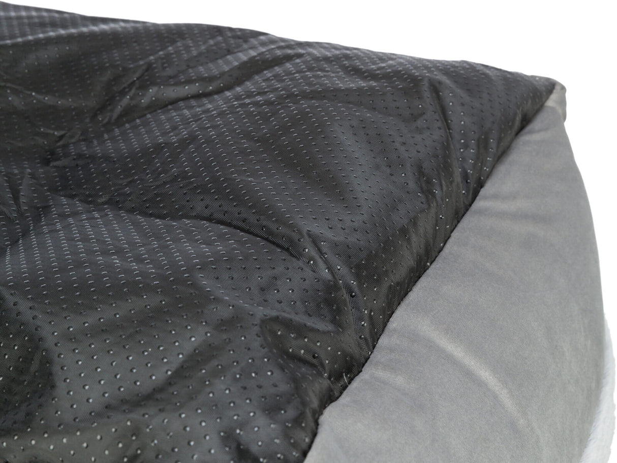 Schwarze, gesteppte Oberfläche mit grauem Rand, möglicherweise ein Teil eines Kissens oder Bettes.