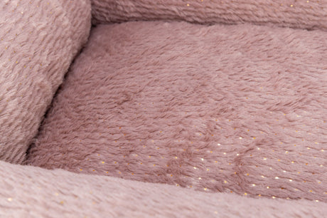 Rosa Plüschstoff mit goldenen Punkten in Nahaufnahme.