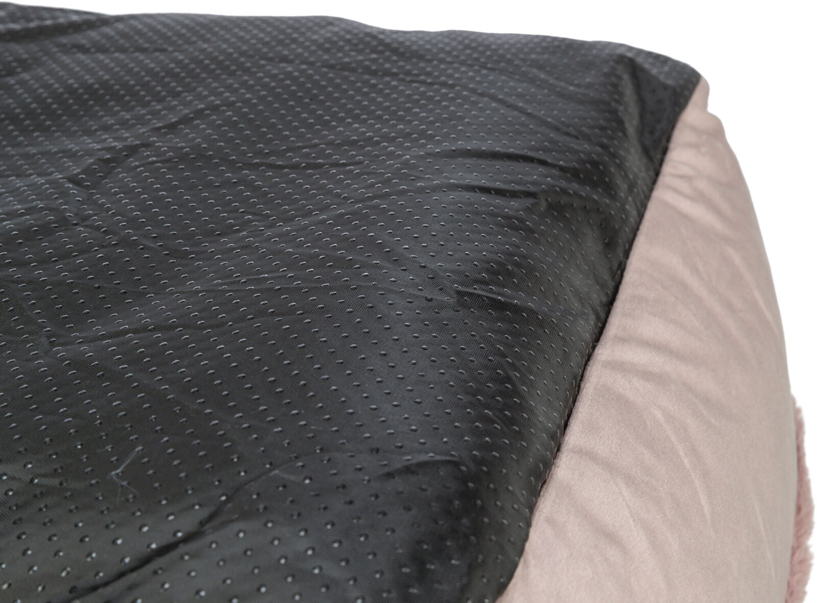 Schwarze, gepunktete Oberfläche neben einem beigen, weichen Textilbereich, Nahaufnahme.