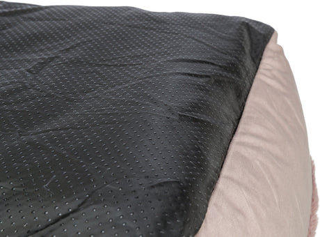 Schwarze, gepunktete Oberfläche neben einem beigen, weichen Textilbereich, Nahaufnahme.