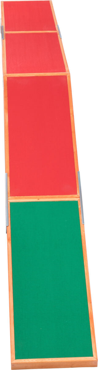Klappbare Rampe mit abwechselnd roten und grünen Flächen und hellem Holzrahmen.