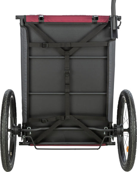 Fahrradanhänger in Schwarz und Rot von hinten gesehen mit zwei Rädern und mehreren Gurten sichtbar.