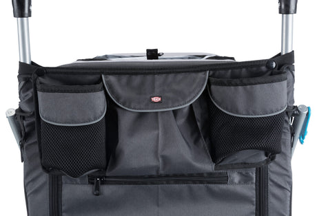 Grau-schwarzer Stoff mit mehreren Taschen und einem Reißverschluss auf einem fahrbaren Gestell.