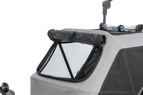 Grau-schwarzer Fahrradanhänger mit Netzfenster und Rollabdeckung auf der Oberseite.