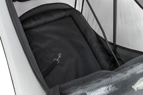 Schwarzer Innenraum eines geschlossenen Fahrradanhängers mit gepolstertem Boden und einem silbernen Karabinerhaken.