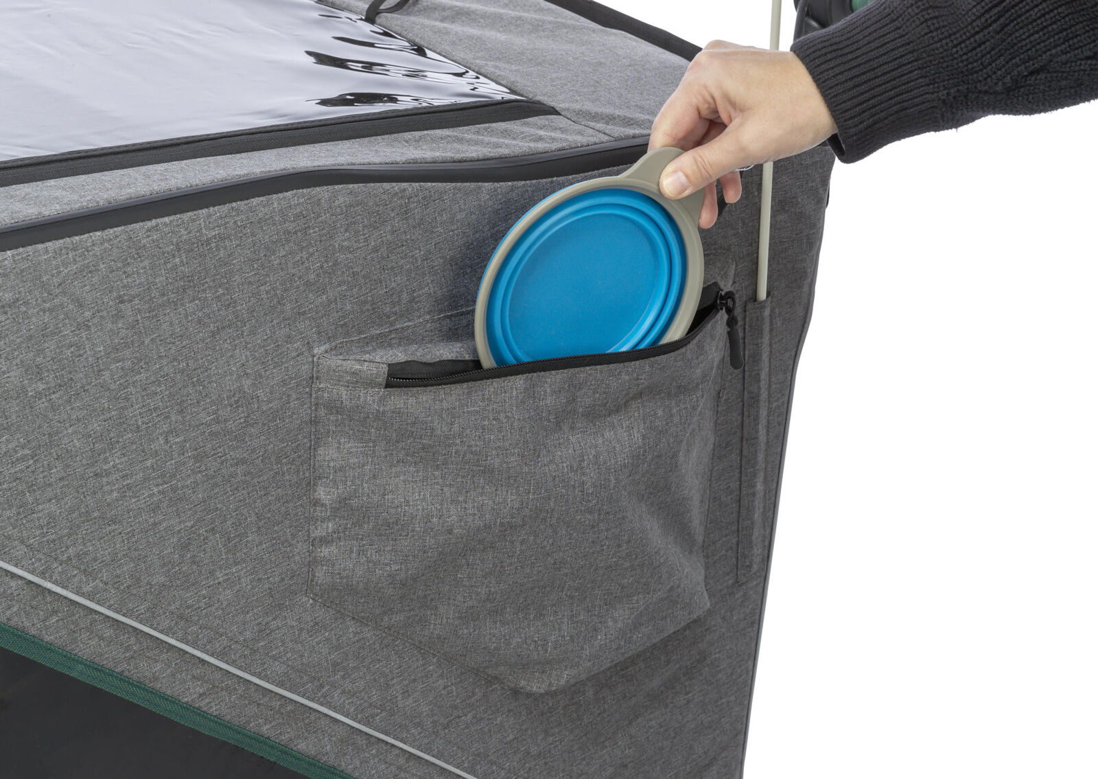 Graue Tasche mit Reißverschluss, eine Hand verstaut einen blauen faltbaren Gegenstand darin.