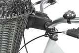 Fahrradkorb aus grauem Geflecht an silbernen Lenker befestigt, daneben eine silberne Klingel.