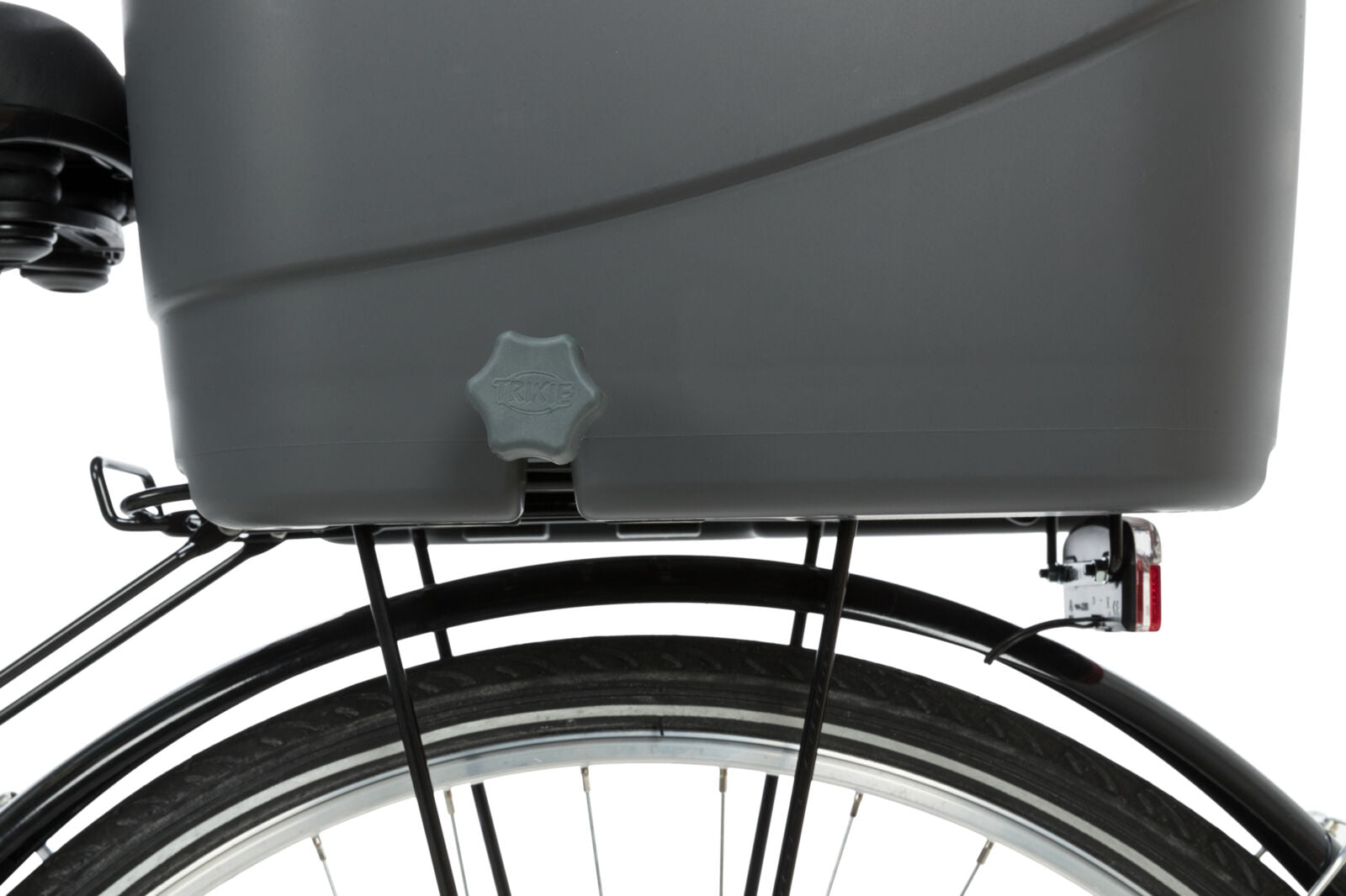 Grauer Fahrradanhänger mit Verschluss über einem schwarzen Fahrradreifen montiert, Herstellername auf Verschluss sichtbar.