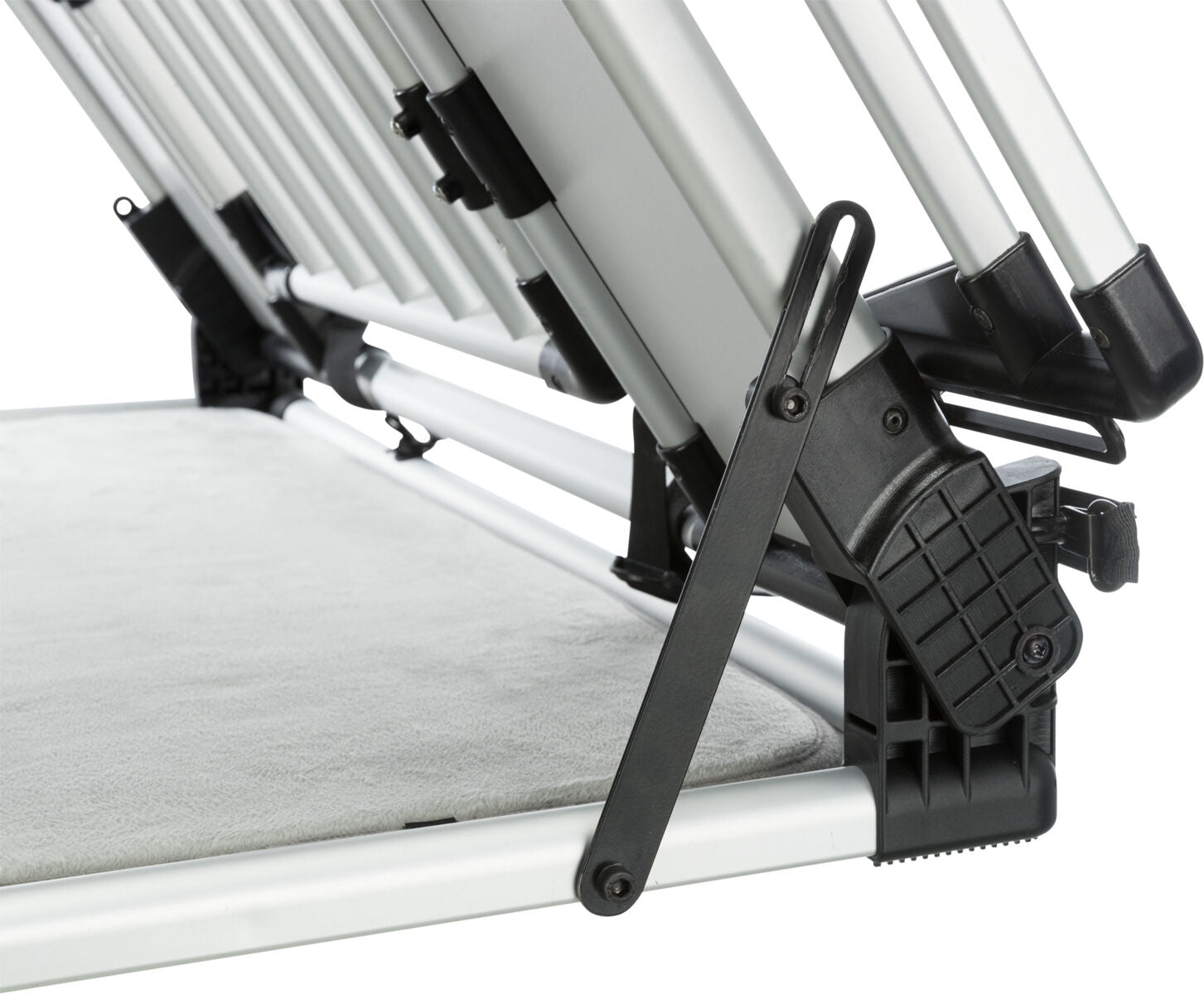 Metallgestell mit schwarzen Kunststoffelementen seitlich auf einer hellen Stoffunterlage montiert.