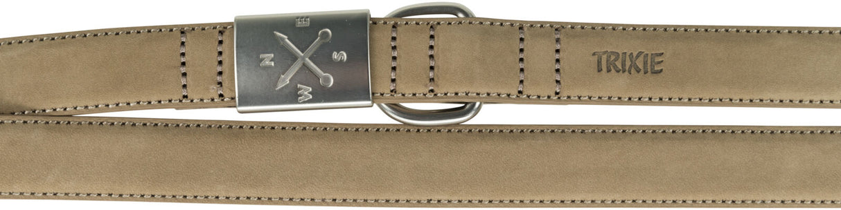 Ein beigefarbener Gürtel mit einer silbernen Metallschnalle und eingravierten Buchstaben sowie dem Schriftzug "TRIXIE".