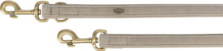 Zwei beige Leinen mit Messingkarabinern und aufgesticktem Label, auf hellem Hintergrund.