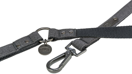 Graues Hundehalsband mit Metallring und Karabinerhaken, an dem ein rundes Trixie-Emblem hängt.