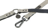 Grau-schwarze Hundeleine mit Karabinerhaken und Metallplakette, Markenname "Trixie" erkennbar.