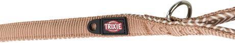 Beiges Hundehalsband mit TRIXIE-Logo und Metallring, zeigt gewebte Struktur und gemusterten Rand.