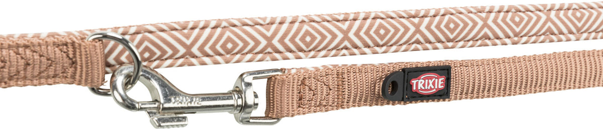 Beige Hundeleine mit geometrischem Muster und Metallclip, Markenname "Trixie" auf schwarzem Etikett.