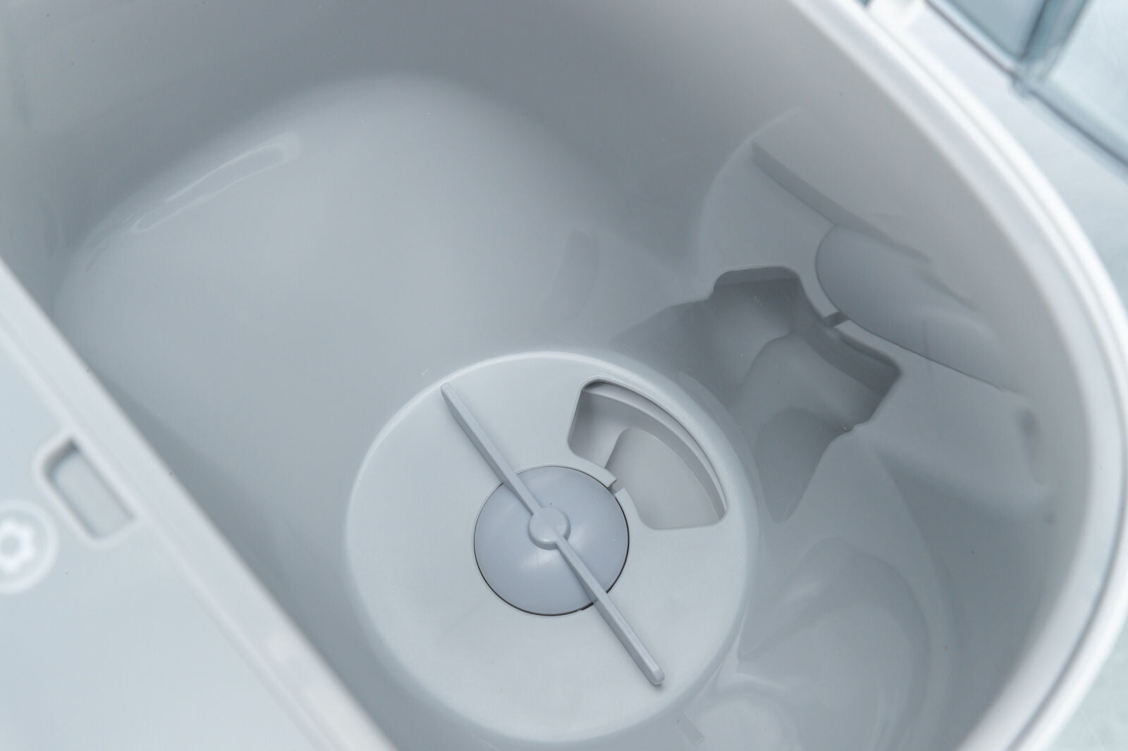 Grauer, runder Behälter mit zentraler Öffnung und symmetrischem Design, glänzende Oberfläche, Seitenansicht.