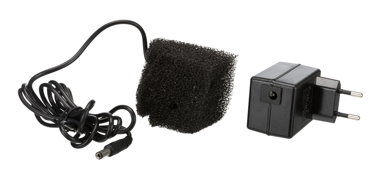 Ein schwarzes Netzteil mit europäischem Stecker neben einem schwarzen Schaumstoffstück und einem Kabel.