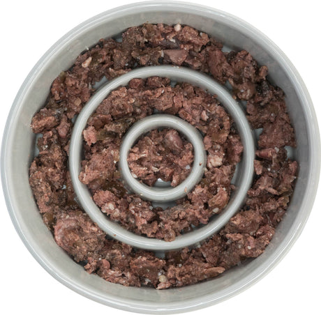 Grauer Napf mit Spiralmuster, gefüllt mit braunem, krümeligem Futter.