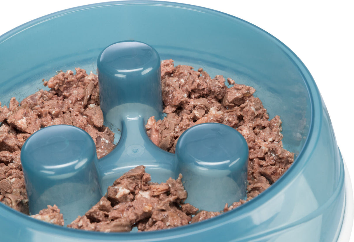 Eine blaue Futterschale mit drei erhobenen Strukturen, gefüllt mit braunem Futter.