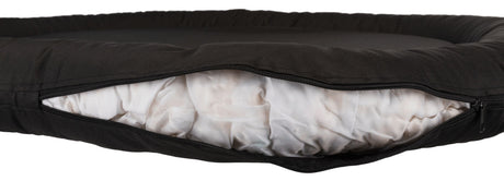 Schwarzes Kissen mit Reißverschluss, das weiße gepolsterte Füllung zeigt, aufgenommen in einer Nahaufnahme.