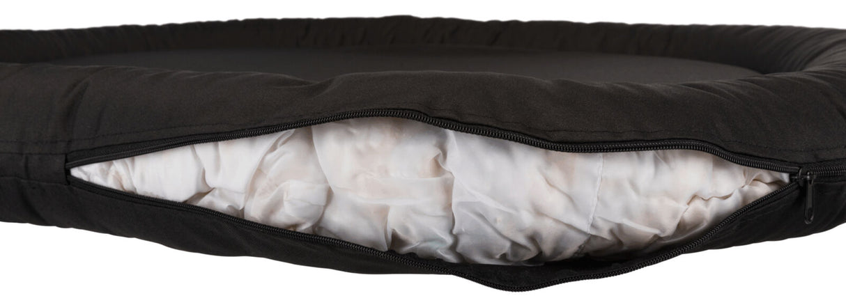Schwarzes Kissen mit Reißverschluss, das weiße gepolsterte Füllung zeigt, aufgenommen in einer Nahaufnahme.