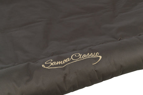 Dunkelbrauner Stoff mit goldener Stickerei "Samoa Classic" in geschwungener Schrift.