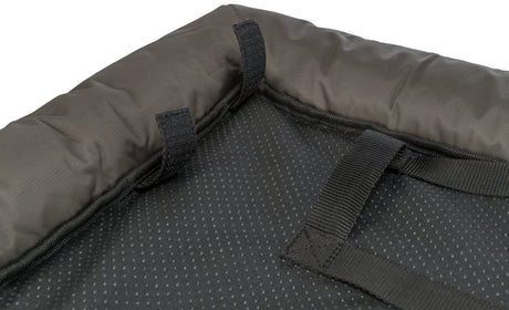 Nahtdetails eines grauen, gepolsterten Textilmaterials mit schwarzem Riemen und genoppter Oberfläche.