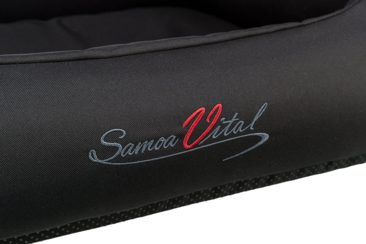 Schwarzes Material mit aufgesticktem Schriftzug "Samoa Vital" in roter und grauer Schrift.