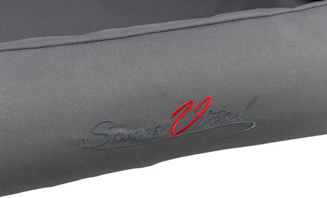 Graues Textil mit aufgestickter Schrift in Rot und Blau, teilweise lesbar als "Samoa Vital".
