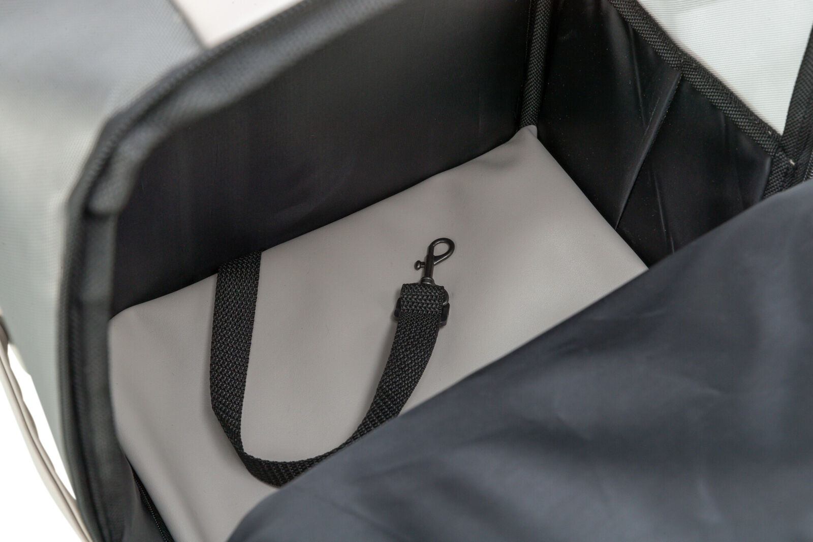Innenansicht eines schwarzen und grauen Behälters mit einem schwarzen Gurtband und einem Haken.