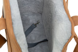 Innenansicht einer beigefarbenen Tasche mit weicher, grauer Fütterung und einem befestigten Gurt mit Karabinerhaken.