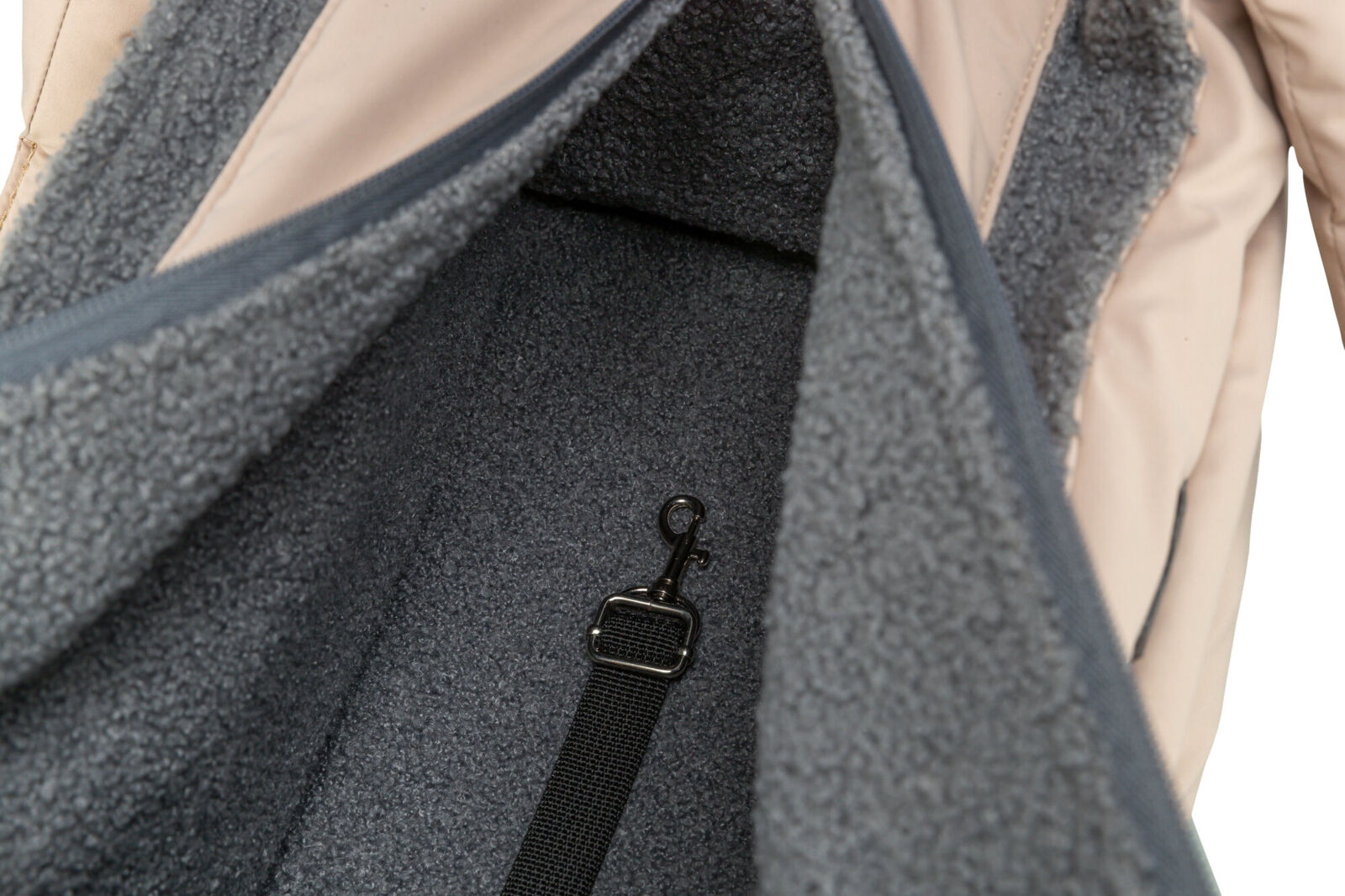 Geöffneter Rucksack mit grauem, flauschigem Innenfutter und schwarzem Karabinerhaken an einem Gurt.