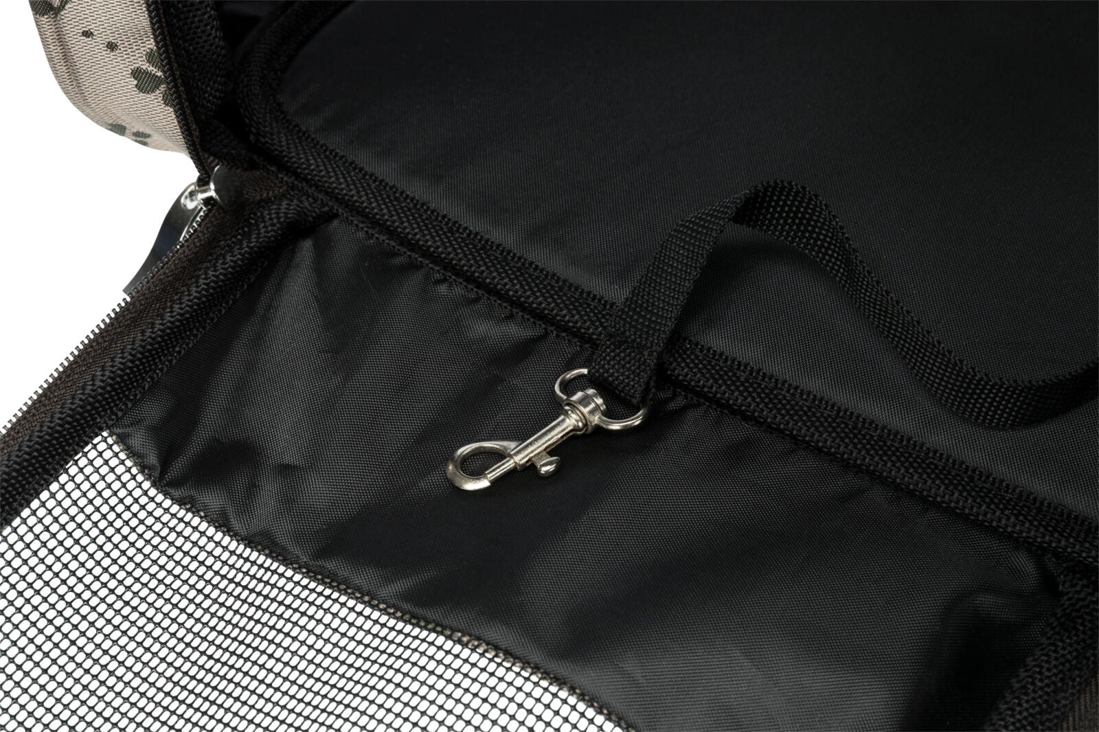 Schwarzer Stoff mit Netzgewebe und Karabinerhaken, umgeben von hell gemustertem Material.