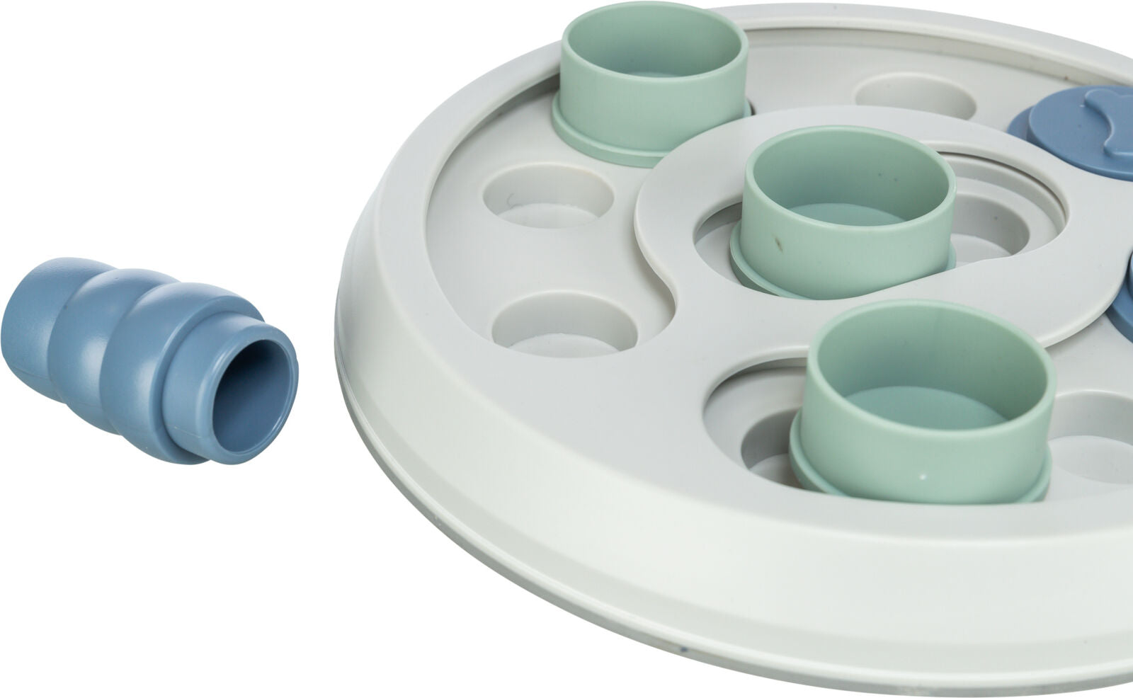 Rundes weißes Puzzle-Spielzeug mit blauen und grünen beweglichen Teilen auf einer ebenen Fläche.