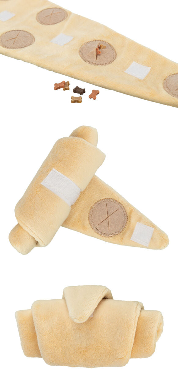 Beigefarbene Plüschrolle mit Klettverschlüssen und kreisförmigen Nähten, neben kleinen, bunten Knochen.