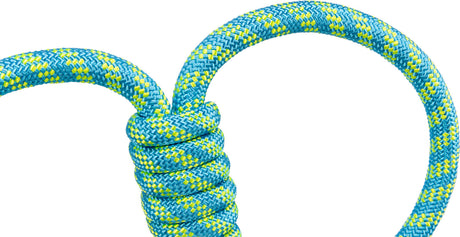 Ein blau-gelb geflochtenes Seil mit einem detaillierten Knoten, Nahaufnahme auf weißem Hintergrund.