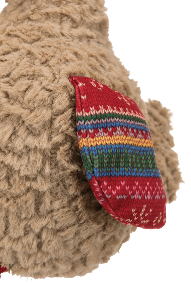 Plüschstruktur in Beige mit einem roten Stoffdetail im bunten Streifenmuster.