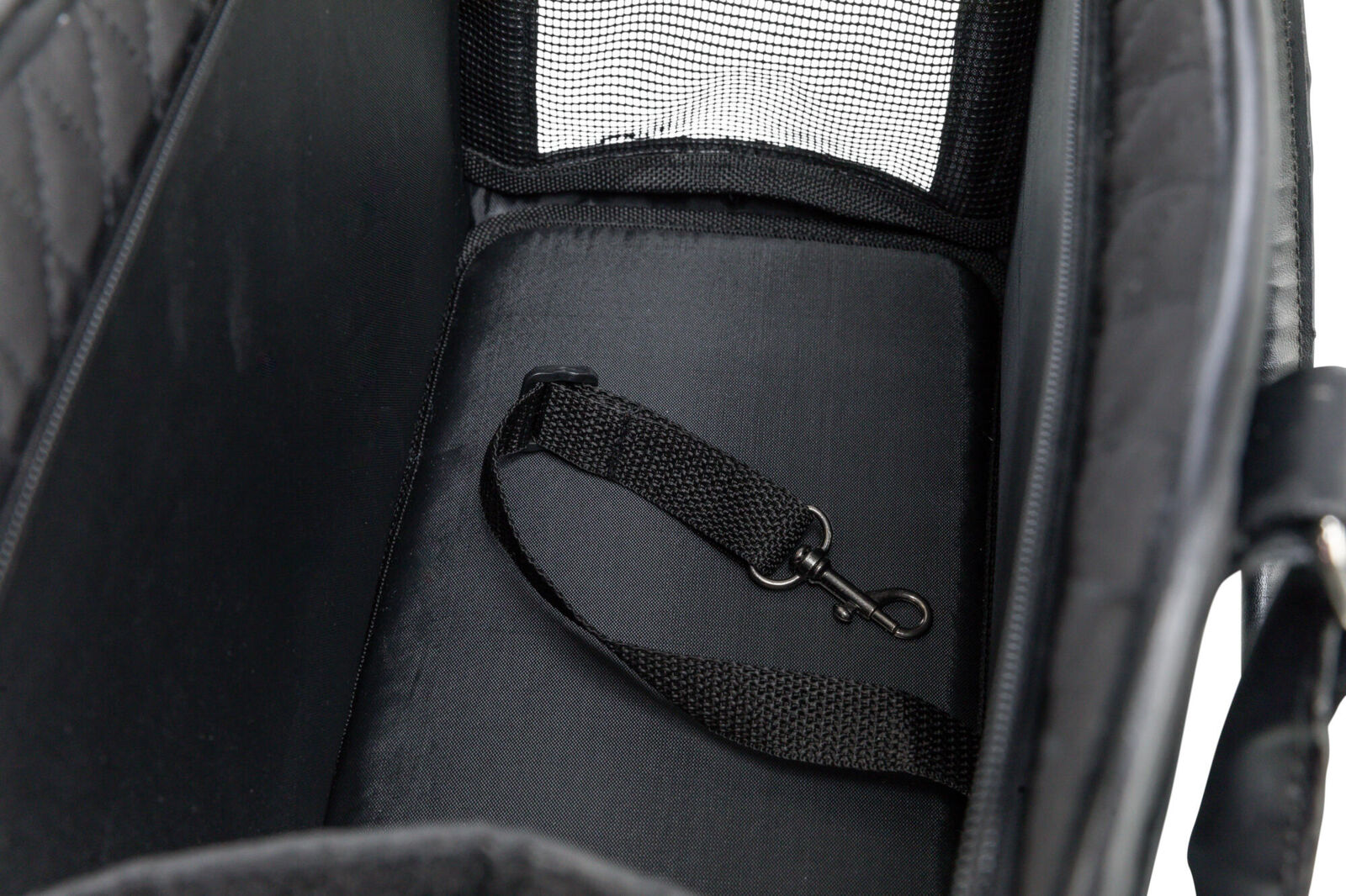 Schwarzer Innenraum mit gepolstertem Boden und Netzeinsatz, Gurt mit Karabinerhaken sichtbar.