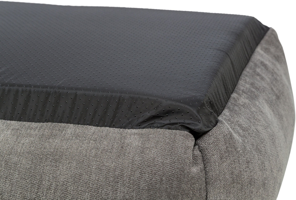 Graue rechteckige Polsterfläche mit schwarzer, punktierter Oberseite aus glattem Material, Detailansicht.