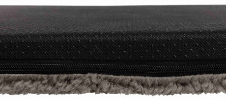 Schwarze, strukturierte Oberfläche über einem Reißverschluss mit darunter sichtbarem grauem, weichem Material.