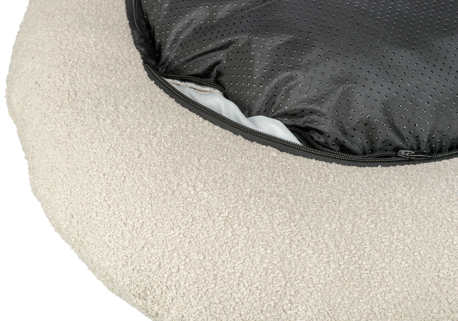 Rundes, beiges Kissen mit weicher, texturierter Oberfläche und schwarzem Reißverschluss, der Innenmaterial zeigt.
