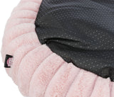 Teil eines runden, rosa Plüschkissens mit schwarzer, gepunkteter Oberfläche und sichtbarem Etikett.