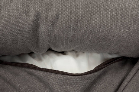 Grau melierter Stoff mit geöffneter Reißverschlussöffnung, die weißes Inneres eines Kissens zeigt.