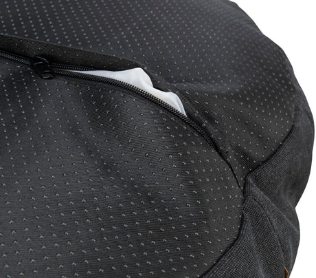 Schwarzer Stoff mit kleinen, weißen Punkten und einem teilweise geöffneten Reißverschluss, darunter weißer Stoff sichtbar.