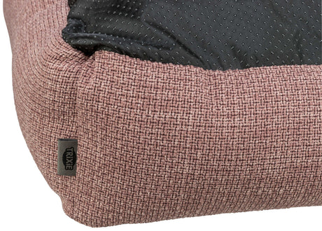 Nahaufnahme eines rosafarbenen, gewebten Stoffs mit schwarzem, gepunktetem Material an der Oberseite.