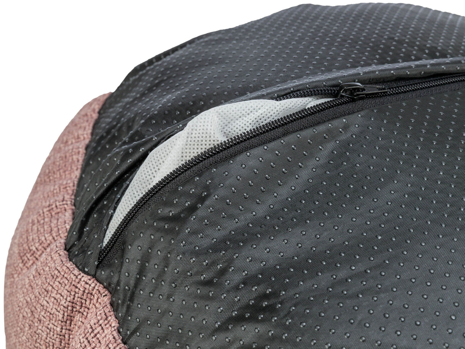 Schwarzer, gepunkteter Stoff mit Reißverschluss über rosa, gewebtem Material auf einer Tasche oder einem Bezug.