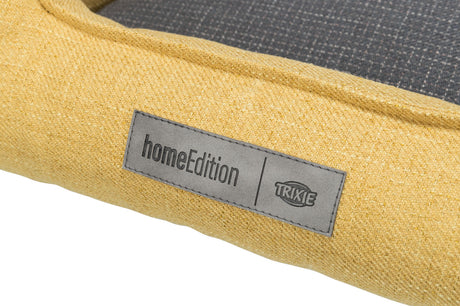 Gelbes Gewebe mit grauem Etikett, darauf schwarzer Text "homeEdition" und "TRIXIE" in Markenlogo.