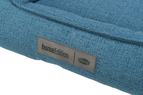 Blaues Textilbett mit Label "homeEdition TRIXIE" auf grauem Stoffetikett sichtbar.