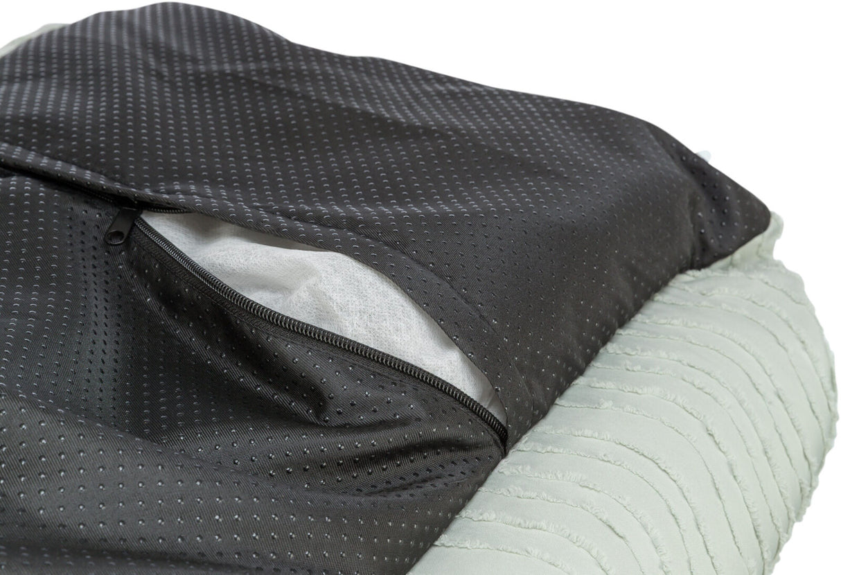 Schwarzes Textil mit Punktmuster und offenem Reißverschluss zeigt darunterliegendes weißes Gewebe.